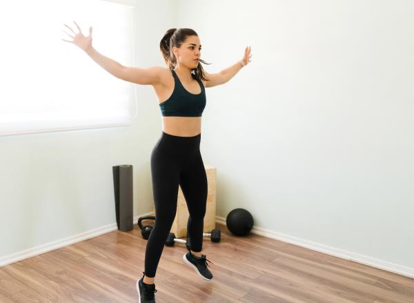 woman doing jumping jacks, co<em></em>ncept of exercises to stay fit when short on time