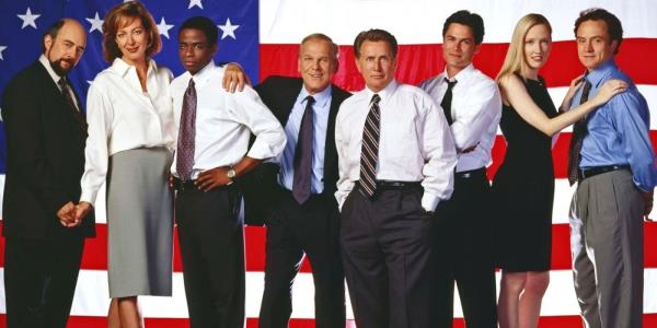 The entire cast of The West Wing against an American flag